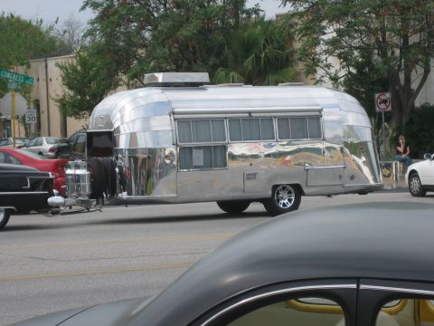 1996 Ford Bronco - A vintage Airstream trailer is seen on the side of a street with other vehicles present.