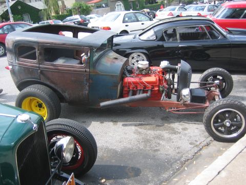 1996 Ford Bronco - A custom hot rod with a powerful engine and weathered body sits parked on a street.