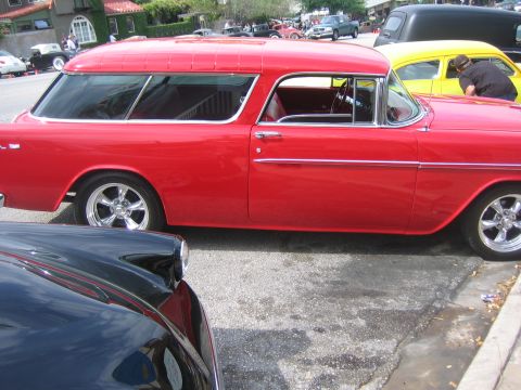 1996 Ford Bronco - Side view of a red 1955 Chevrolet Nomad station wagon with custom wheels.
