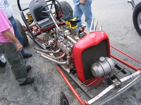 1996 Ford Bronco - A custom hot rod with a prominent red grille and exposed engine is viewed from the front.