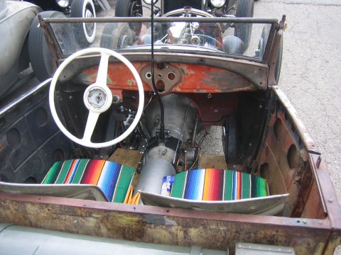 1996 Ford Bronco - Interior view of a custom hot rod with a white steering wheel and striped seat covers.