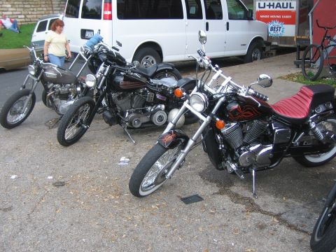1996 Ford Bronco - Several custom motorcycles are parked together on a paved surface with a U-Haul truck in the background.