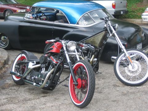 1996 Ford Bronco - A pair of custom choppers are parked in front of a vintage black car a bright blue roof.