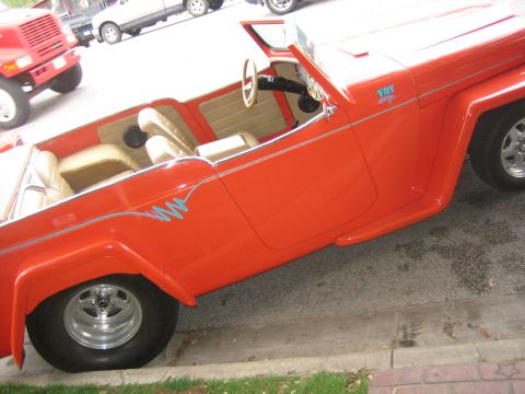 1996 Ford Bronco - An orange jeep with a custom paint job and tan interior is parked on the side of the road.