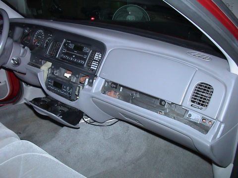 2000 Ford Crown Victoria - The interior of a 2000 Ford Crown Victoria shows a disassembled dashboard with the radio and center console removed.