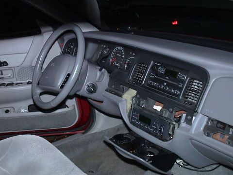 2000 Ford Crown Victoria - The interior of a 2000 Ford Crown Victoria shows the dashboard, steering wheel, and partially disassembled radio.