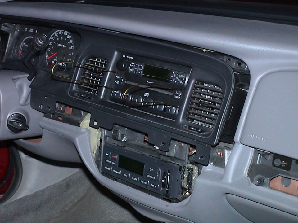 2000 Ford Crown Victoria interior dashboard with radio removed, showing vents and gauges