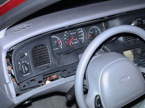 2000 Ford Crown Victoria - The interior of a 2000 Ford Crown Victoria shows the dashboard and steering wheel with some components disassembled.