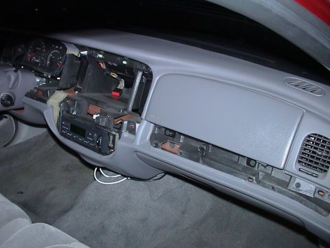 2000 Ford Crown Victoria - Wide view across the gray dashboard of a Ford sedan from the passenger side with the upper bezel removed, leaving the climate control head,…