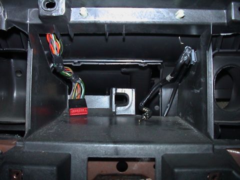 2000 Ford Crown Victoria - Empty double-DIN radio opening in a black dash cavity with the head unit removed, showing the metal mounting cage and center vent housings.…