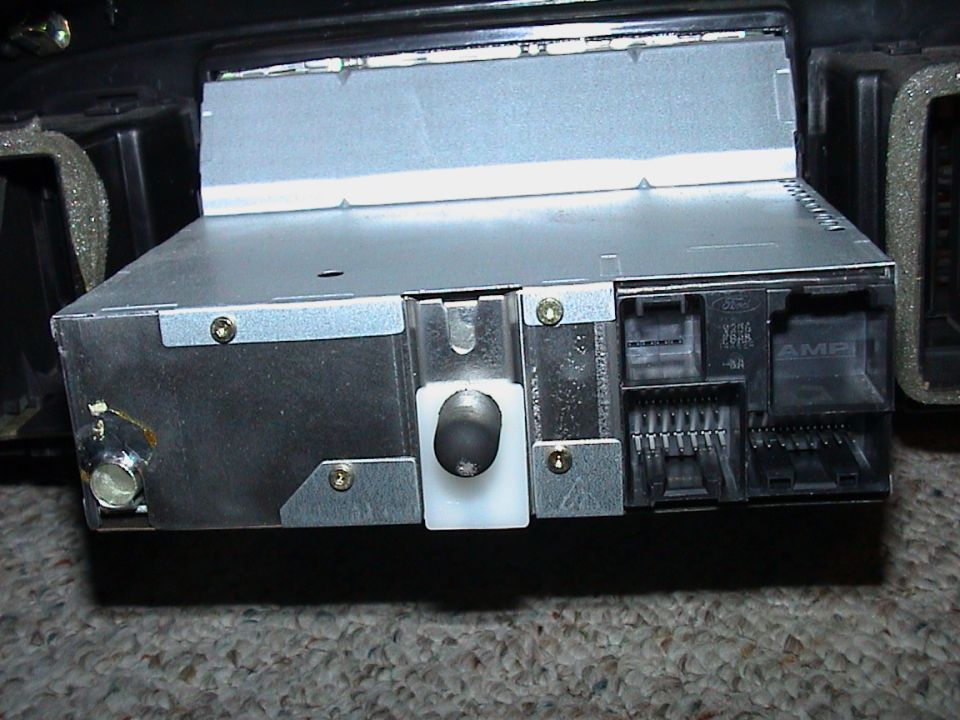 Back of a Ford factory radio removed from the dash, showing wiring connectors and antenna lead
