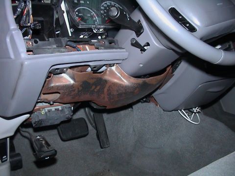 2000 Ford Crown Victoria - Interior view of a 2000 Ford Crown Victoria with dashboard panels removed, revealing wiring and mechanical parts.