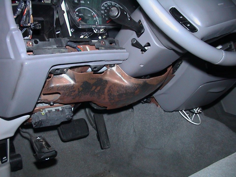 2000 Ford Crown Victoria interior showing exposed dashboard components, steering column, and pedals