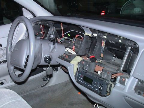 2000 Ford Crown Victoria - Wide interior shot from the passenger side of a grey-trimmed sedan with the dash torn down: the instrument bezel, cluster and radio are out…