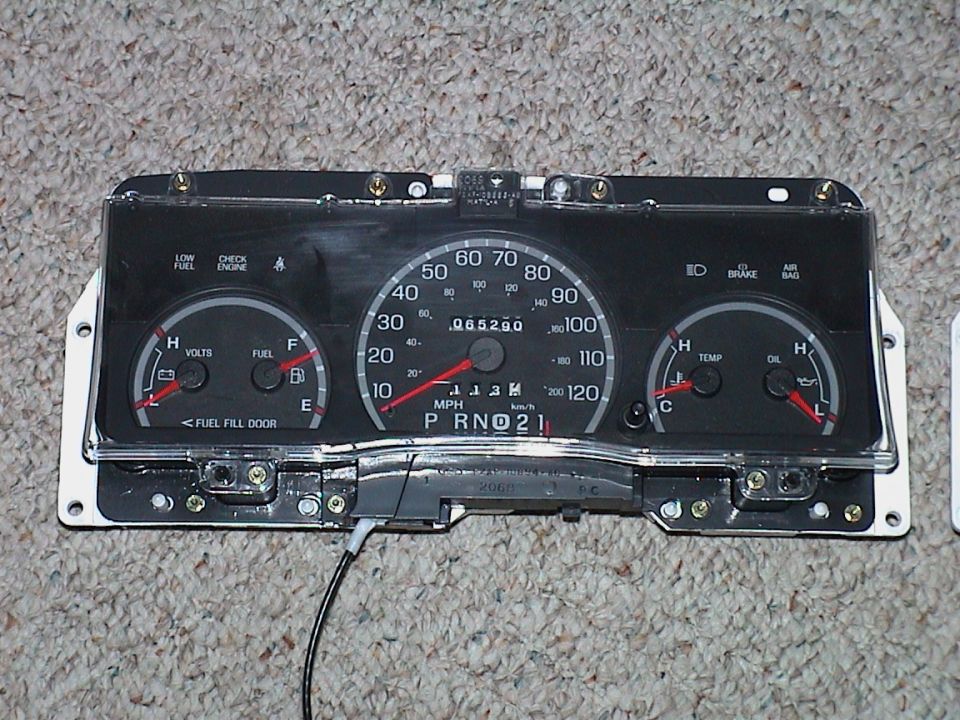 Ford 120 mph instrument cluster removed from car, lying face-up on carpet