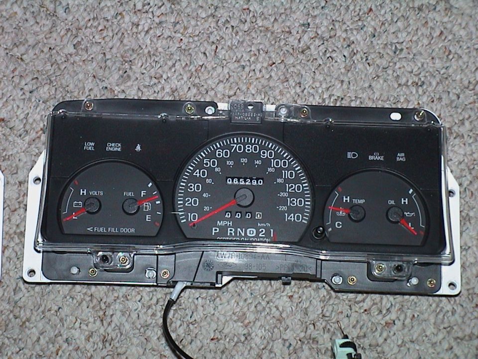 Ford 140 mph gauge cluster on carpet, part number XW7F-10894-AA on housing