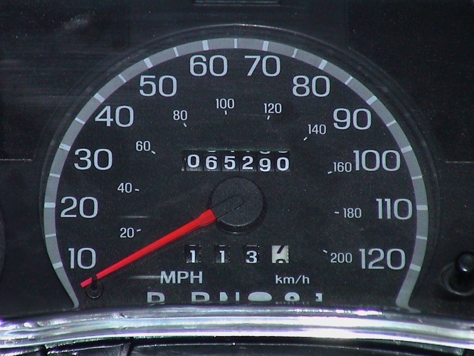 Close-up of a 120 mph speedometer with odometer reading 065290 miles