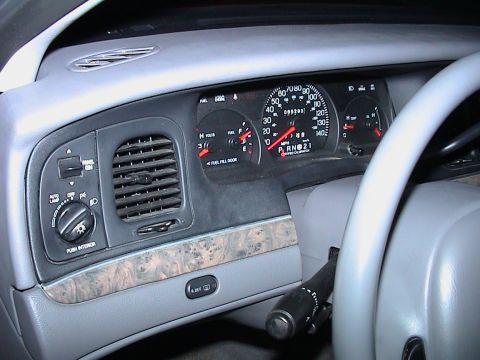 2000 Ford Crown Victoria - Driver-side dashboard of a grey-interior Ford sedan with the instrument cluster reassembled: 140 mph speedometer marked 'CERTIFIED CALIBRAT…