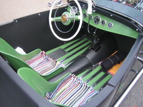 1996 Ford Bronco - The interior of a custom car shows green seats and a white steering wheel with a black dashboard.