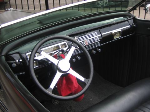 1996 Ford Bronco - The dashboard of a vintage car features a chrome grille and a clock.