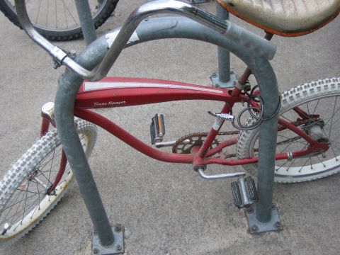 1996 Ford Bronco - A red bicycle with white tires is locked to a bike rack.
