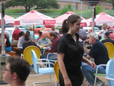 1996 Ford Bronco - People enjoy a meal outdoors with a collection of classic cars visible behind them.