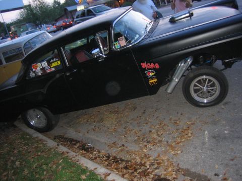 1996 Ford Bronco - A modified 1956 Ford sedan with custom exhaust and racing decals sits parked on a street.