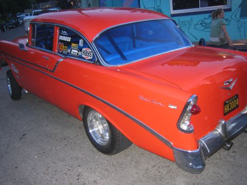 1996 Ford Bronco - This 1956 Chevrolet Bel Air features a vibrant orange paint job and numerous racing decals on its windows.