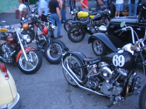 1996 Ford Bronco - A collection of custom motorcycles and a hot rod are gathered, with people in the background.