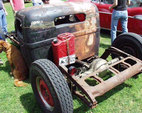 1996 Ford Bronco - Rat rod pickup truck with a red gas can and Arkansas license plate 51-522. Dog sits to the left.