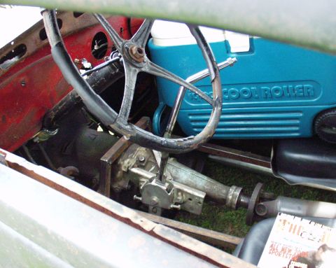 1996 Ford Bronco - The interior of a vehicle is visible, a steering wheel, transmission, and a blue cooler.