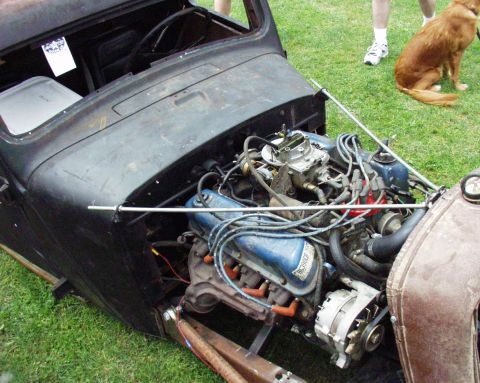 1996 Ford Bronco - The engine bay of a custom hot rod reveals a blue Ford engine, carburetor, and alternator.