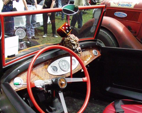 1996 Ford Bronco - Interior view of a custom hot rod with a red steering wheel and dashboard, next to another vintage Ford.