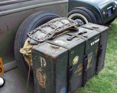 1996 Ford Bronco - Vintage luggage and spare tire mounted on a vehicle, with another car in the background.