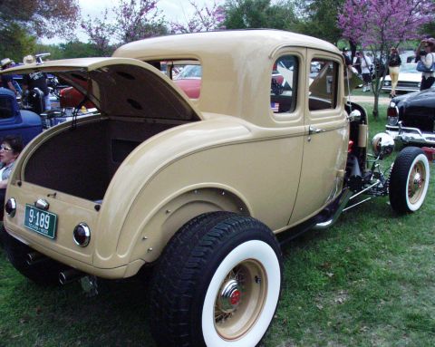 1996 Ford Bronco - A tan 1932 Ford coupe hot rod is displayed outdoors with its trunk open, showing off its custom modifications.