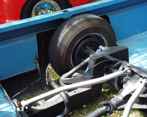 1996 Ford Bronco - The rear axle and suspension components of a vehicle are visible, with a portion of another vehicle in the background.