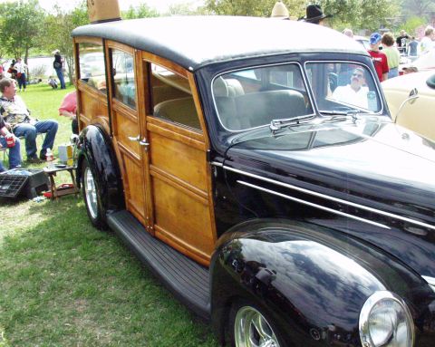 1996 Ford Bronco - A classic 1939 Ford woody wagon is parked on grass, with people in the background.
