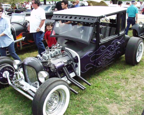 1996 Ford Bronco - A custom hot rod with a powerful engine and distinctive flame paint job is displayed outdoors.