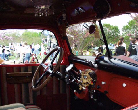 1996 Ford Bronco - Customized interior of a red vehicle, seen from the driver's seat, with a skull ornament on the dashboard.