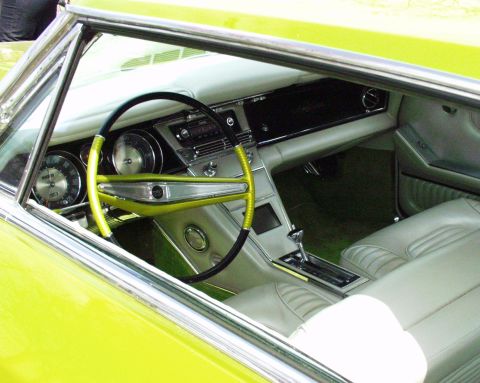 1996 Ford Bronco - The interior of a classic car features a distinctive steering wheel and dashboard with prominent gauges.
