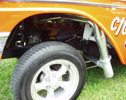 1996 Ford Bronco - The side view of a custom drag car highlights its engine, exhaust, and wheel assembly.