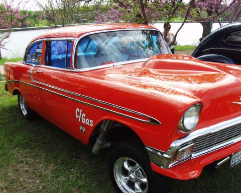 1996 Ford Bronco - A modified 1955 Chevrolet coupe with a prominent hood scoop and racing decals sits on display.