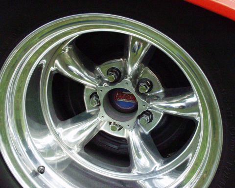 1996 Ford Bronco - Close-up of a chrome five-spoke wheel with a red and blue center cap.