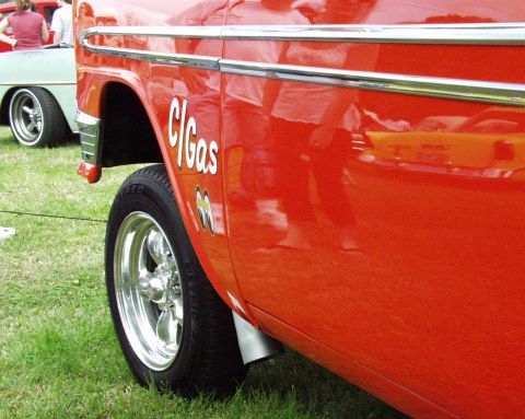 1996 Ford Bronco - A classic red car with custom graphics is parked on grass, with another vehicle visible behind it.