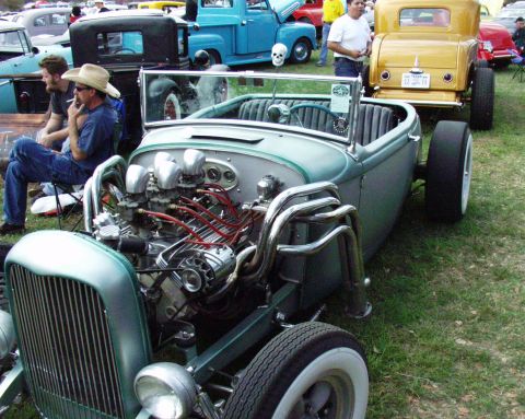 1996 Ford Bronco - A custom hot rod with a powerful engine is displayed at an outdoor event.