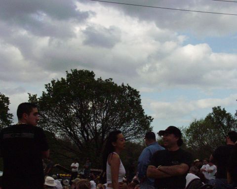 1996 Ford Bronco - People gathered outdoors with trees and a cloudy sky overhead.