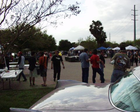 1996 Ford Bronco - An outdoor gathering takes place under a cloudy sky, with tents and trees dotting the landscape.