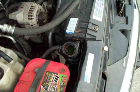 1988 Ford Bronco - Close-up view of a vehicle's engine bay, showing the battery and radiator components.