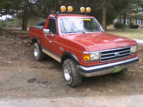 1989 Ford Bronco - Red 1989 Ford Bronco with custom smiley face light bar on the roof rack.