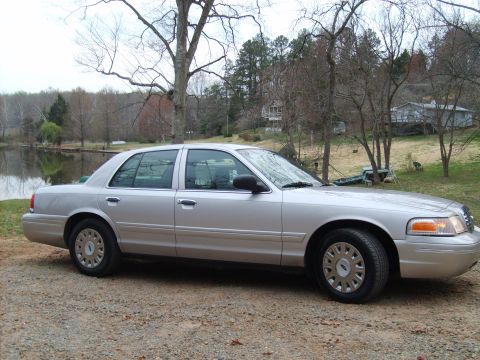 2004 Ford Crown Victoria - Side view of a silver 2004 Ford Crown Victoria parked outdoors near a lake.